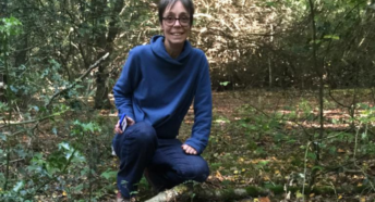Image of Jacquetta Fewster, Coordination Officer at the Surrey Climate Commission in a field of mushrooms